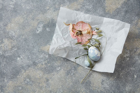 在纸上的复活节彩蛋与花装饰在石头背景。复活节彩蛋与花卉装饰