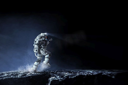 星球表面摄影照片_穿着宇航服的宇航员在行星表面运行。混合媒体。太空人跑得很快。混合媒体