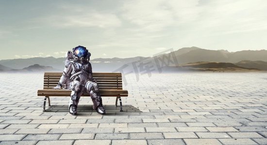 坐火箭人摄影照片_太空人坐在木凳上。混合媒体。火箭人坐板凳。混合媒体