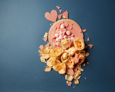 节日背景贺卡上的玫瑰和心形华夫饼在黑暗的背景上。心形华夫饼和玫瑰花瓣