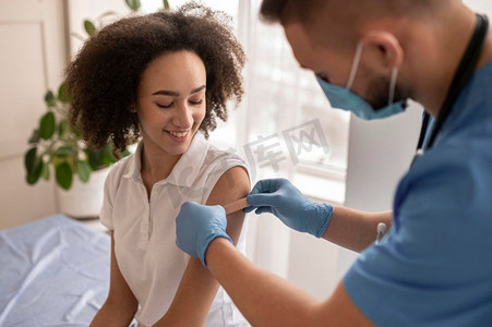 医生在接种疫苗后将贴片患者手臂