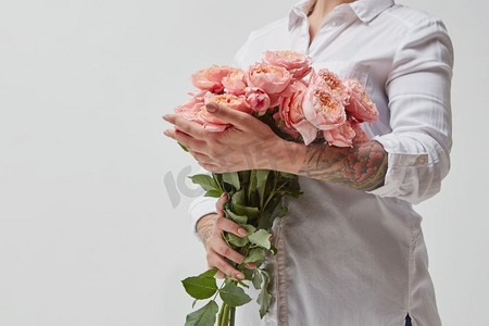 一位女士捧着一大束粉红色的玫瑰。情人节，母亲节。’’一束花的女孩
