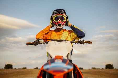 越野摩托车骑手的肖像脱下保护头盔后成功的比赛。正面拍摄。肖像摩托车越野车手起飞头盔