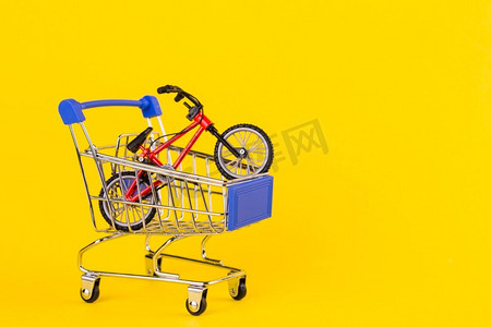 小自行车玩具购物车反对黄色背景