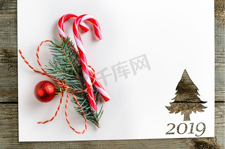 在2019年圣诞卡或新年背景的冷杉树形状的剪纸在木桌子上。桌上的冷杉形剪纸
