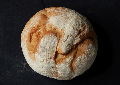 圆形面包孤立在黑色背景。一条面包