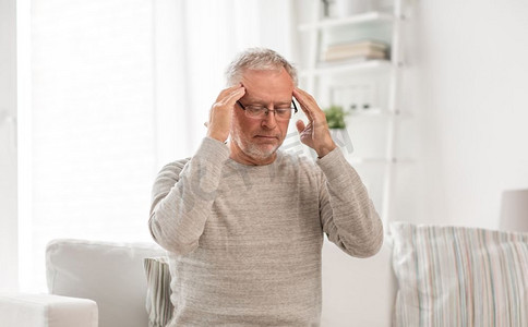 头痛摄影照片_保健、压力、老年与人的观念--家中头痛的老人。家中头痛的老年男子