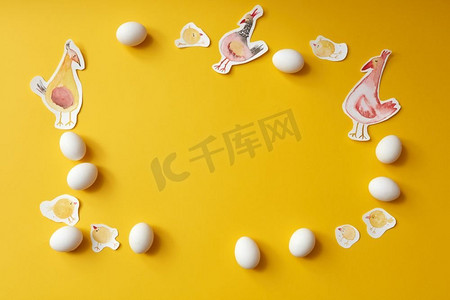 鸡和鸡蛋摄影照片_框架画白色的鸡和鸡蛋在黄色背景与地方的文字，平奠定。鸡蛋和彩绘鸡的框架