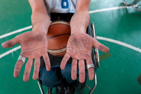 在竞技场上一场令人筋疲力尽的比赛后,残疾篮球运动员的手.手凳子