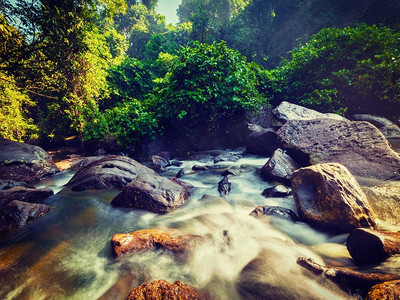 复古金边摄影照片_复古效果过滤了柬埔寨金库伦热带瀑布的潮人风格形象。柬埔寨的热带瀑布