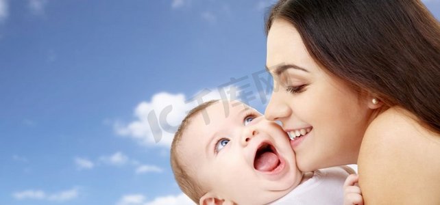 家庭和母亲的概念-快乐微笑的年轻母亲和小婴儿天空背景。母亲和婴儿在天空的背景