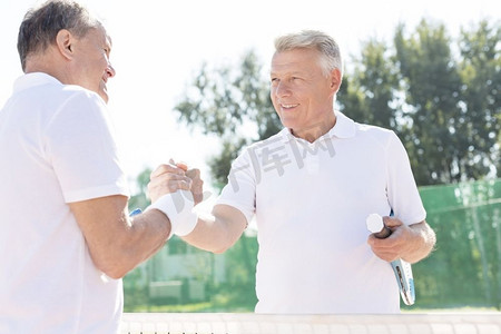 微笑的男人打招呼，而站在网球场比赛在晴天