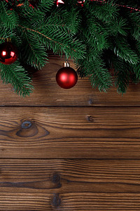 圣诞树装饰框架在木背景，冷杉树枝，红色小玩意儿，文本的复制空间.圣诞树装饰背景