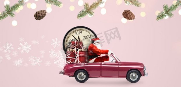 圣诞节到了摄影照片_圣诞节倒计时到了。汽车上的圣诞老人在送新年礼物和粉色背景的时钟。汽车上的圣诞老人倒计时