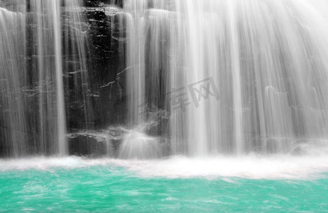 缓慢摄影照片_以缓慢的快门速度拍摄的瀑布的一部分，以平滑的水。一个瀑布的一部分，以缓慢的快门速度拍摄，以平滑，