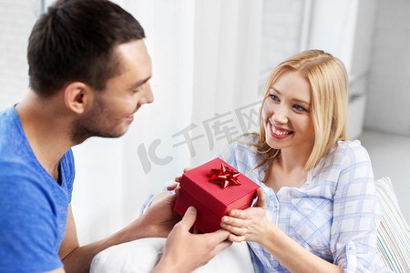 惊喜，情人节和人们概念快乐的夫妇在家里有礼品盒。家里有礼品盒的幸福夫妻