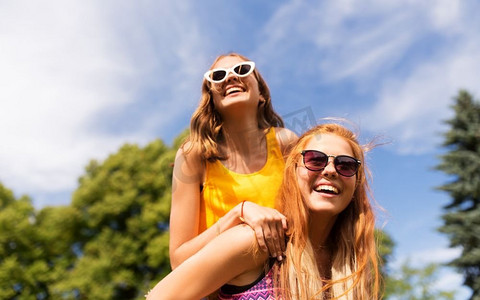 休闲，人和友谊的概念-快乐的少女或朋友在夏令营玩得开心。快乐的十几岁的女孩在夏季公园玩得开心