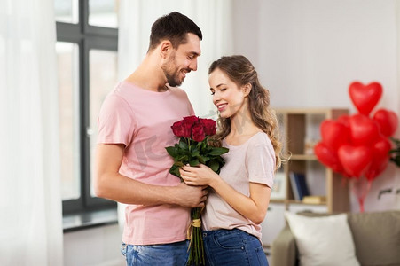 情人节，关系和人的概念-幸福的夫妇在家里拥抱着一束鲜花。情人节情人节在家里送花