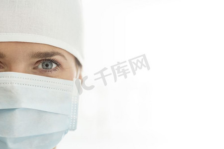白色背景下女医生戴着外科口罩和帽子的特写肖像