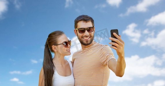 用手机的情侣摄影照片_科技与人的概念--夏天，幸福的情侣用智能手机自拍。夏天，幸福的情侣用智能手机自拍
