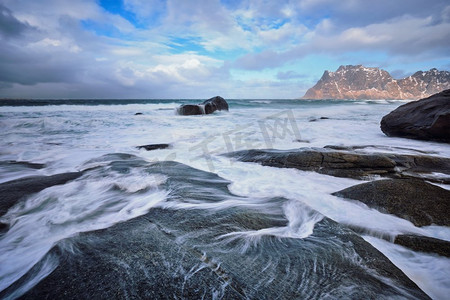 亚克力发光字摄影照片_冬天的挪威海峡湾海滩上积雪的岩石。乌塔克列夫海滩，罗福滕群岛，挪威。挪威峡湾海滩