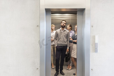 自信的商务人士站在办公室的电梯里