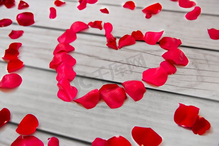 爱，浪漫，情人节和假日概念—关闭红色玫瑰花瓣在心脏形状。关闭红色玫瑰花瓣在心脏形状