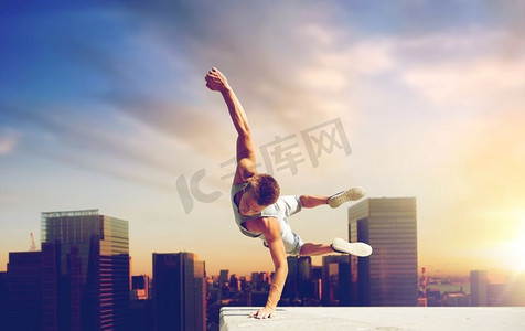 跳高摄影照片_极限运动，跑酷和人的概念—年轻人跳高在东京城市背景。男子进行跑酷跳跃超过东京市