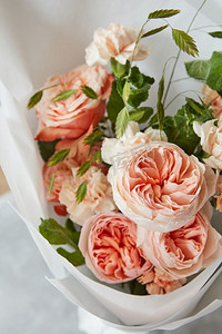 情人玫瑰花摄影照片_美丽的花束橙色玫瑰在白色背景。玫瑰花花束的形式给予作为礼物或礼物给某人。玫瑰在白色背景