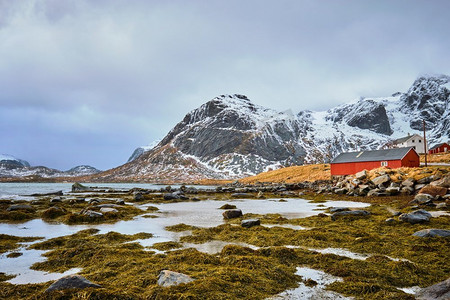 红色云摄影照片_挪威峡湾里的红色罗布房子。挪威罗弗敦群岛。红色罗布房子和峡湾在挪威