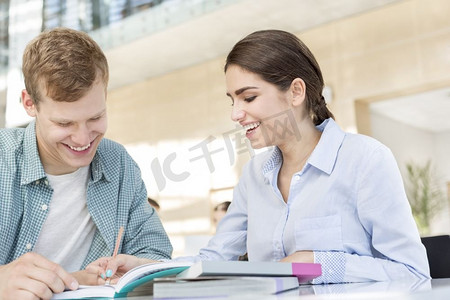 微笑的朋友讨论书，而坐在桌子在图书馆
