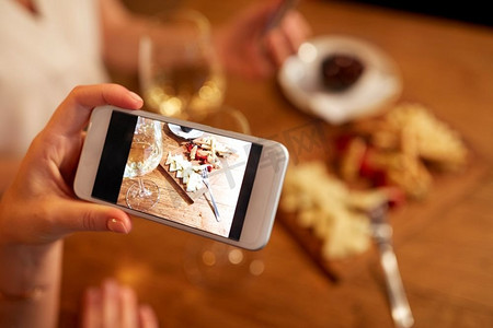 人、技术和生活方式理念-在酒吧用智能手机手绘食物。在酒吧用智能手机手绘食物