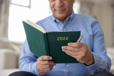 男人在家里拿着2022年新年日记的特写