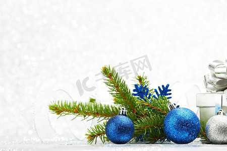 闪光绿色摄影照片_圣诞节冷杉分支和装饰在抽象银背景