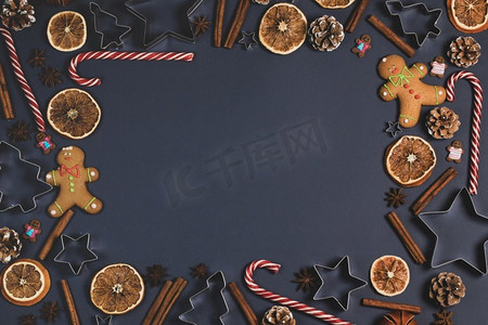 圣诞美食摄影照片_圣诞食品边框姜饼饼干，香料和装饰在黑暗背景圣诞节美食背景