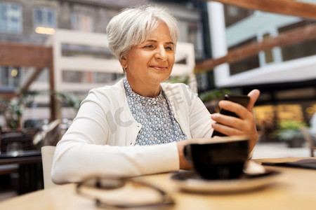 与人连接摄影照片_技术，老年和人的概念—愉快的高级妇女与智能手机在街道咖啡馆。快乐的高级妇女与智能手机在街头咖啡馆
