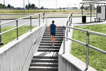健身，运动和健康的生活方式概念—年轻人在城市楼上跑步。年轻人跑上楼