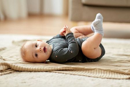 童年，孩子和人的概念-可爱的女婴躺在家里的地板上。可爱的女婴躺在家里的地板上