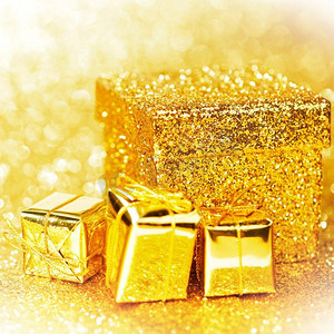 金金色卡摄影照片_装饰金盒与节日礼物在闪亮的闪光背景
