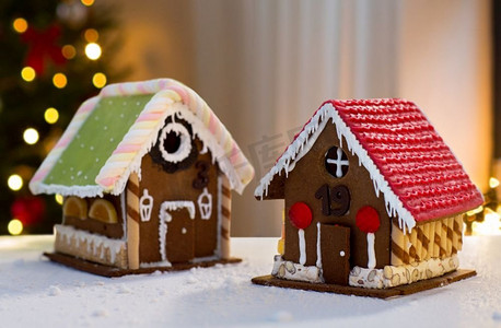 烹饪、度假和烘焙概念-圣诞树上的姜饼屋的背景。圣诞树彩灯下的姜饼屋