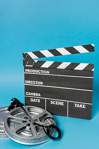 相机录像摄影照片_带胶片卷轴胶片条纹的隔板对蓝色背景