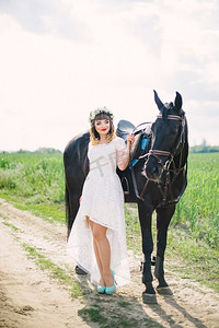 身着白色连衣裙的红唇女孩靠近一匹黑马