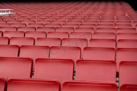 座椅红色摄影照片_空的红色座位排在足球场足球