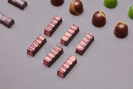 不同大小的巧克力糖果在灰色背景。五颜六色的糖果背景