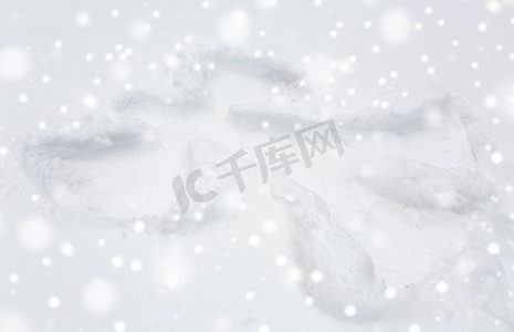 天使的剪影摄影照片_寒假和圣诞节的概念-天使剪影或印花在雪面上。雪面上的天使剪影或印花