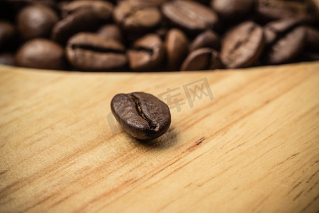 cofee摄影照片_棕色烤咖啡豆在木板背景。