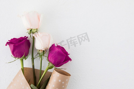 玫瑰花组合摄影照片_玫瑰花包装纸白色桌子