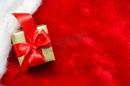 节日，礼物，圣诞节的概念。小金盒与礼品系在红色背景装饰弓