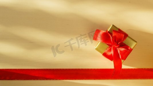 假期，现在的概念。金色小盒子与礼品系装饰蝴蝶结和红丝带框架