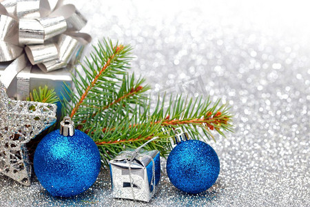 圣诞节冷杉树枝和装饰在银闪光背景
